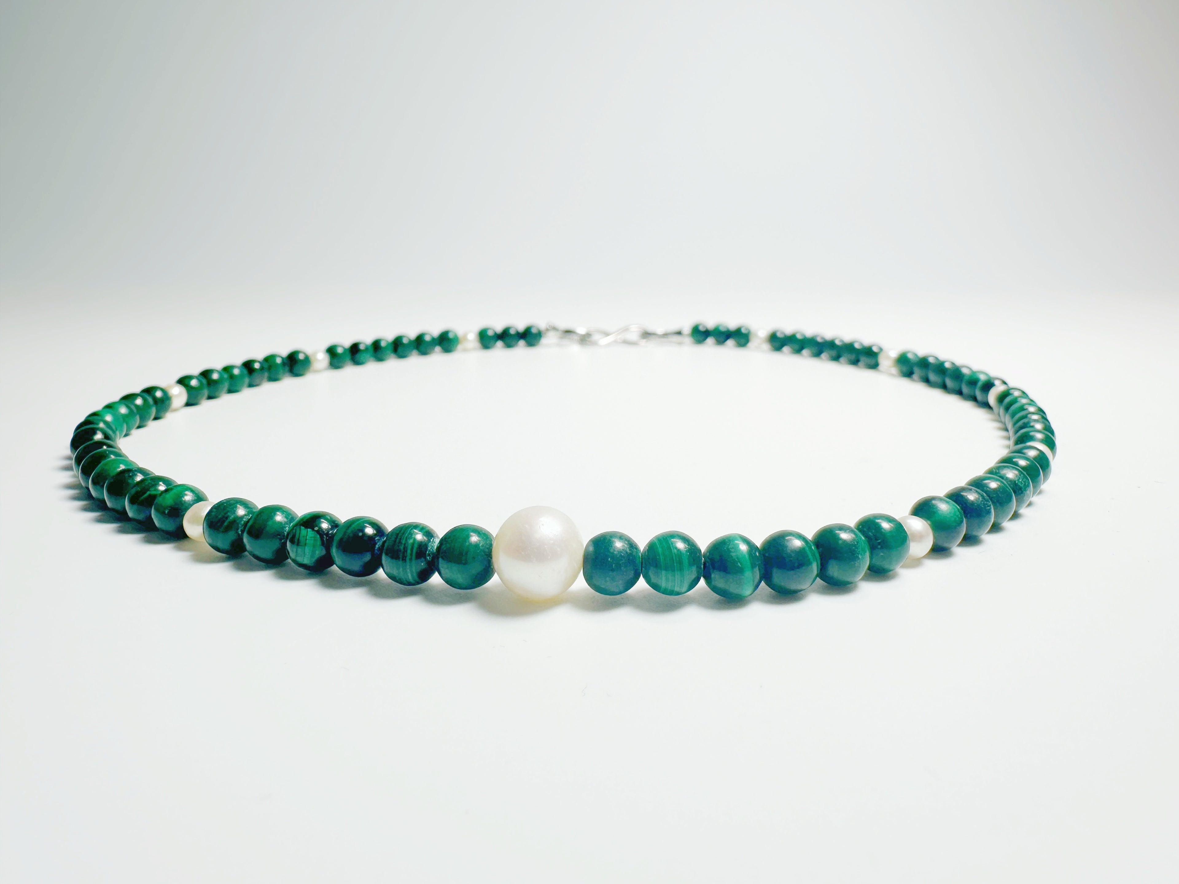 The Bì(碧) handcrafted necklace featuring lustrous white pearls and vibrant green malachite stones arranged in elegant pattern