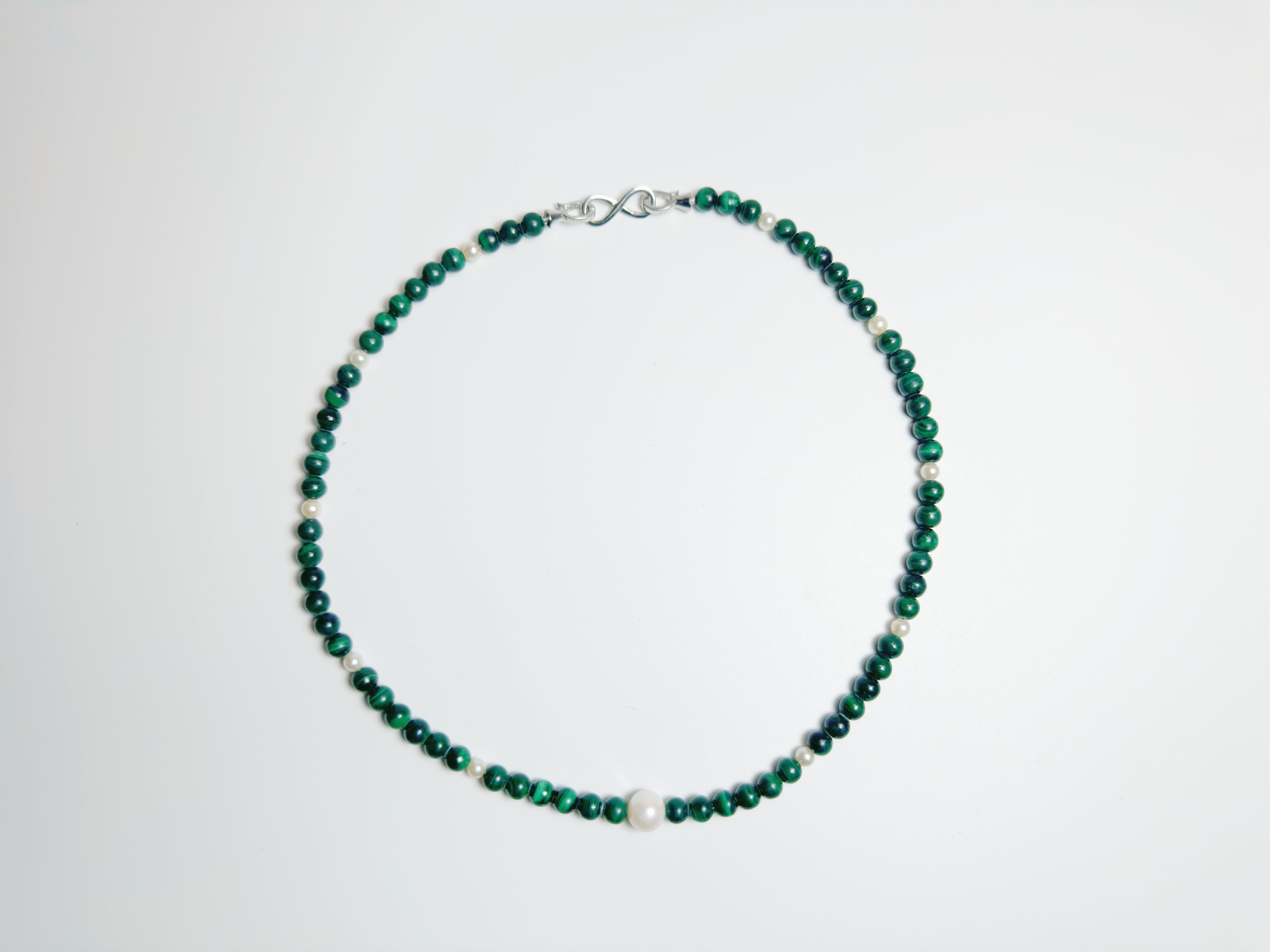 The Bì(碧) handcrafted necklace featuring lustrous white pearls and vibrant green malachite stones arranged in elegant pattern